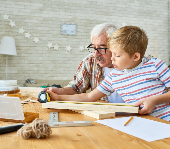 Ein Großvater baut mit seinem Enkel ein eigenes Vogelahus aus Holz